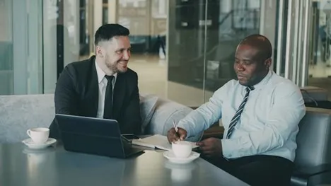 Two professionals discussing structured settlement regulations