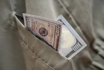 A $100 bill tucked into a shirt pocket