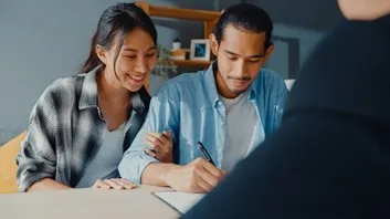 Couple reviewing financial documents together at a table
