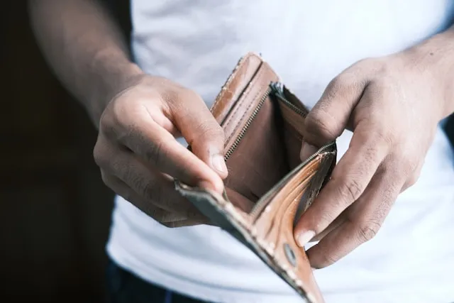 Person using settlement funds to pay off debt with bills and a calculator