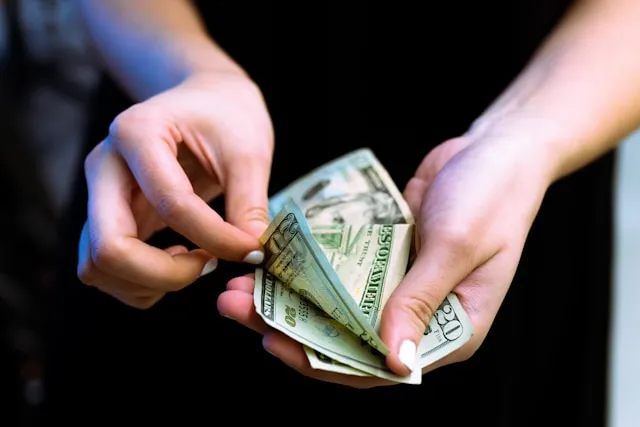 Person weighing financial options with documents and a calculator