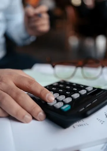 Close-up of hand using calculator to calculate structured settlement payment value