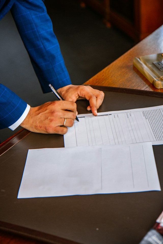 Person in a suit signing legal documents