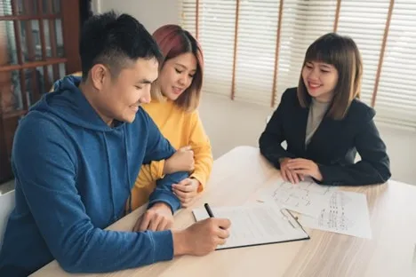 Couple meeting with a financial advisor to sign settlement paperwork
